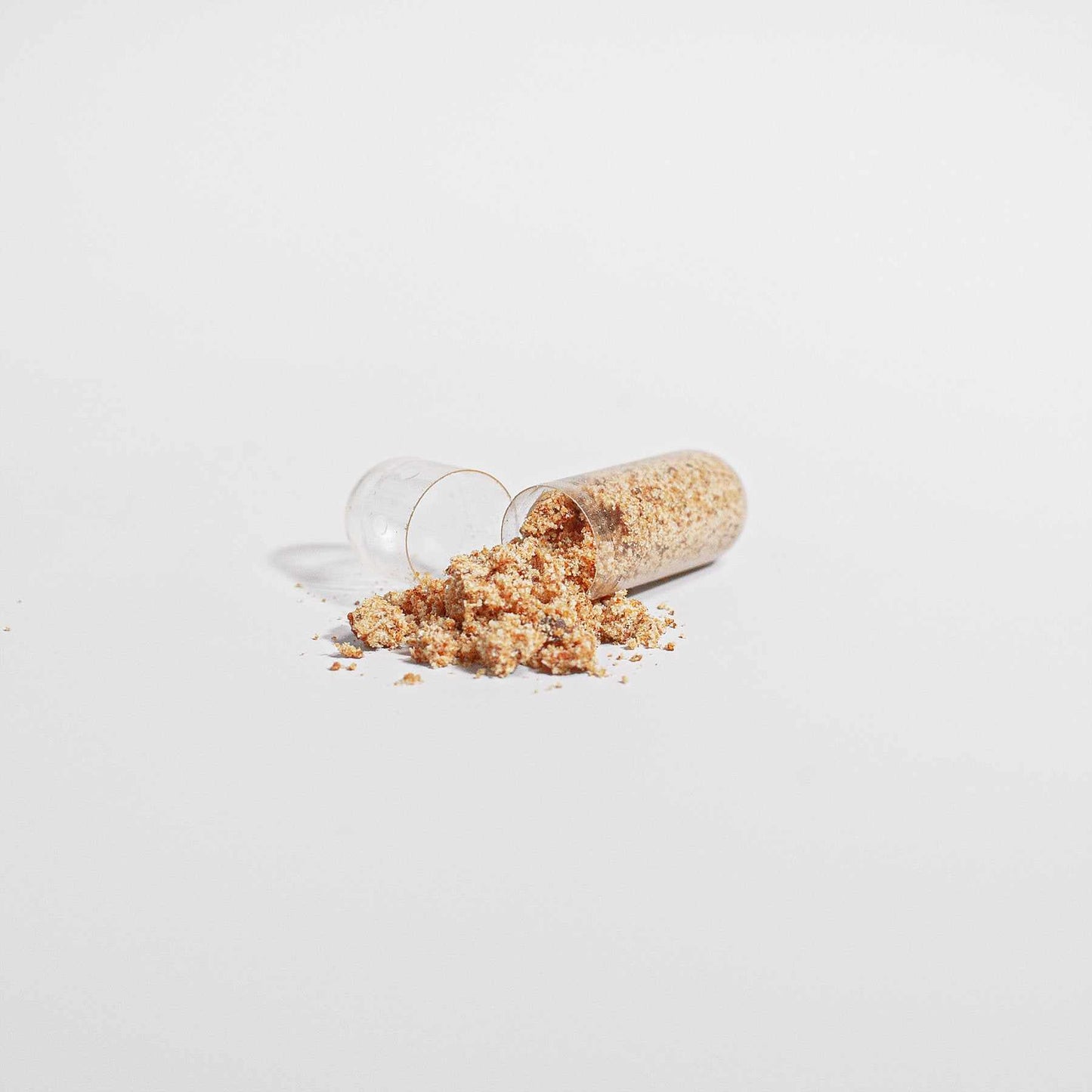 Bee Bread Supplement capsule with natural ingredients scattered.